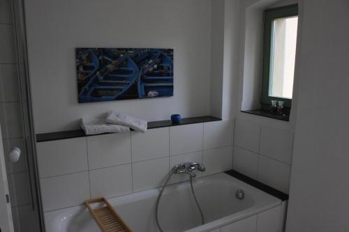a bathroom with a bath tub and a window at Traumhafte Etagenwohnung in Günderzeitvilla in Dresden