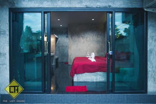 Watthana NakhonThe Loft House Sakaeo的一间卧室配有一张红色的床,上面有两只白色的猫
