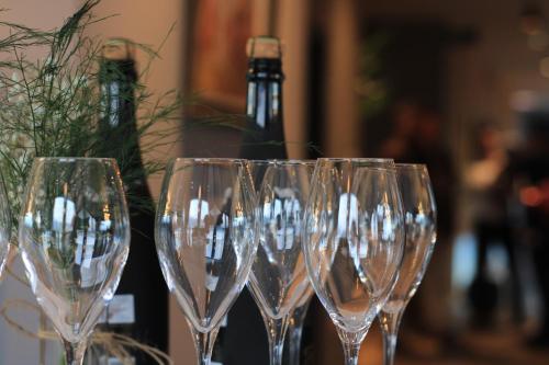 una fila di bicchieri da vino seduti accanto a una bottiglia di vino di Sky Hotel a Prizren