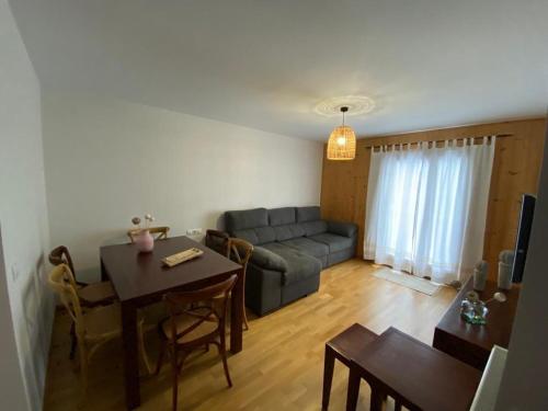 ein Wohnzimmer mit Sofa und Tisch in der Unterkunft Fantástico Apartamento con jardín en Castiello de Jaca VUT HU-20-007 in Castiello de Jaca