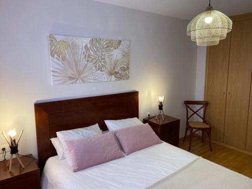 1 dormitorio con 1 cama con 2 almohadas rosas en Fantástico Apartamento con jardín en Castiello de Jaca, en Castiello de Jaca