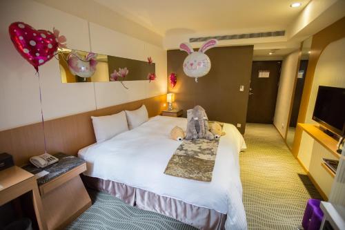 ein Hotelzimmer mit einem Bett mit ausgestopftem Tier darauf in der Unterkunft Ximen Relite Hotel in Taipeh