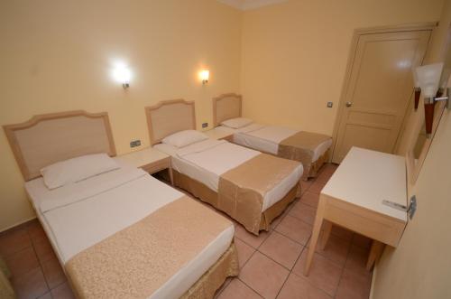 a room with three beds and a table at alenz suite in Marmaris