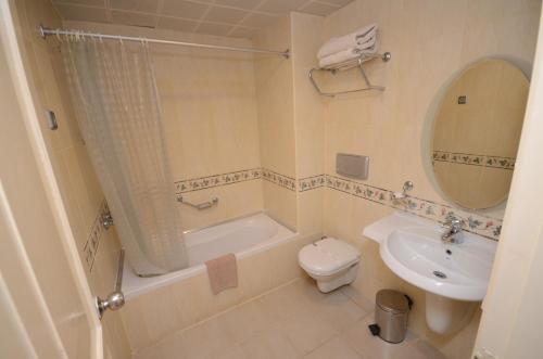 a bathroom with a sink and a toilet and a mirror at alenz suite in Marmaris