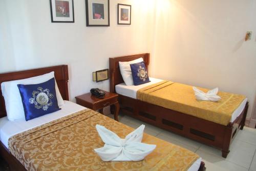 a hotel room with two beds with flowers on them at Bora Sky Hotel in Boracay