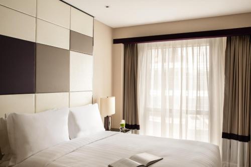広州市にあるJumeirah Living Guangzhouのベッドルーム(白いベッド1台、窓付)