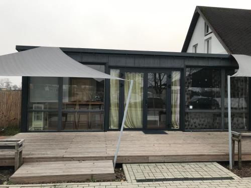 a building with a white umbrella on a wooden deck at Fly in fly out in Mārupe