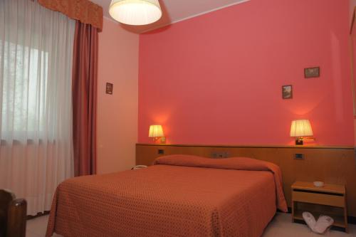 a bedroom with two beds and a red wall at Le Gronde in Cava Manara