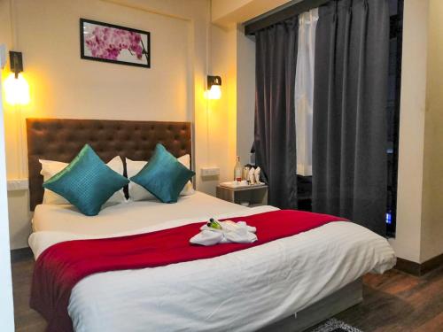 a bedroom with a large bed with towels on it at Humro Himalayan Orchid in Darjeeling