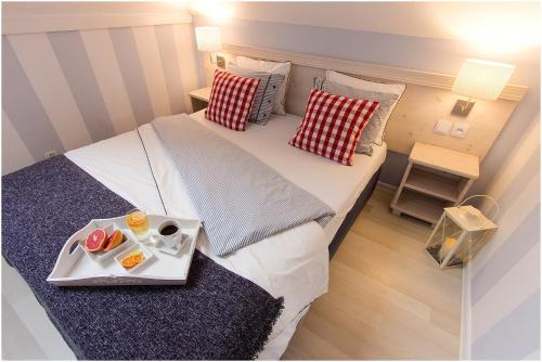 a small room with a bed with a tray of food on it at Willa Karmazyn in Międzyzdroje