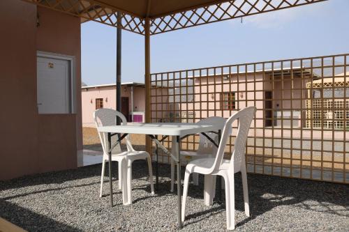 a white table and two chairs on a patio at Jabel shams stars house in Al Ḩamrāʼ