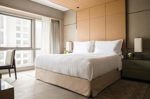 a bedroom with a large bed and a large window at Jumeirah Living Guangzhou in Guangzhou