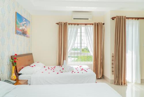 a hotel room with two beds and a window at Sun & Sea Hotel in Phu Quoc