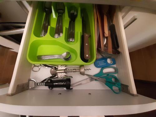 a green drawer with scissors and other kitchen utensils at Apartment in Old Town - view of Mariacki Church in Gdańsk