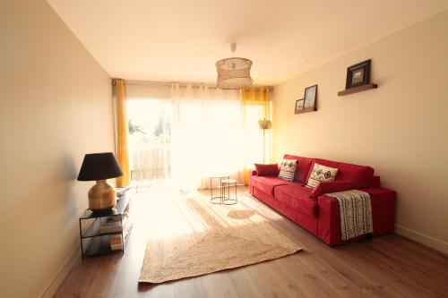 a living room with a red couch and a window at Mon Appart A GERLAND II in Lyon