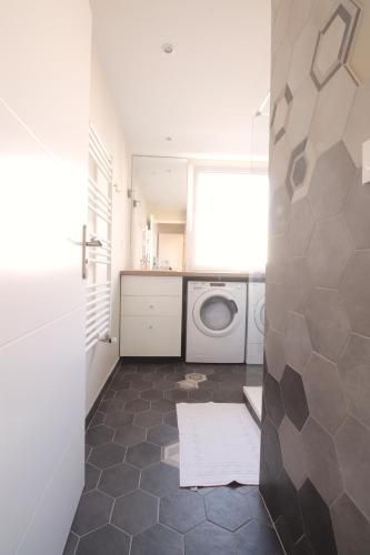a laundry room with a washing machine and a washer and dryer at Mon Appart A GERLAND II in Lyon