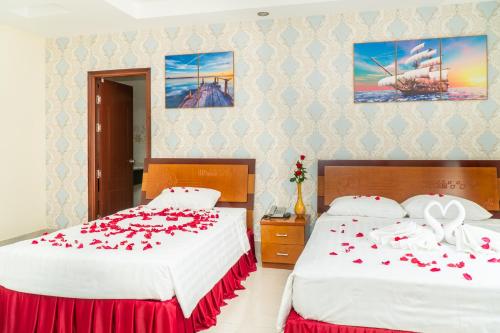 a bedroom with two beds with red roses on them at Sun & Sea Hotel in Phu Quoc