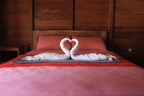 two white swans making a heart on a bed at Watukarung Prapto Homestay in Kalak