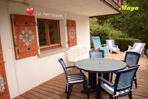 un patio avec une table et des chaises sur une terrasse dans l'établissement Appartements 5 Personnes MAYA et LOUNA, à Xonrupt-Longemer