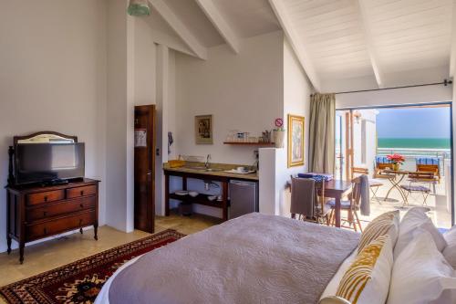 a bedroom with a bed and a desk with a television at Deja-Vu in Paternoster