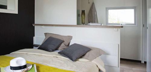 a bedroom with a bed with a hat on it at Camping Domaine du Lac Chambon in Murol