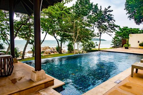 an infinity pool in a villa with the ocean in the background at Pawanthorn Samui - SHA Plus in Chaweng
