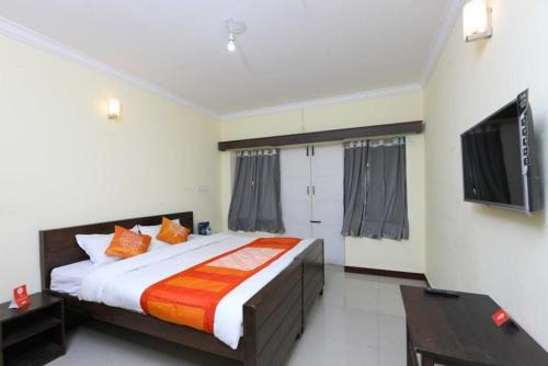 a bedroom with a large bed and a flat screen tv at Bruton resorts in Kodaikānāl