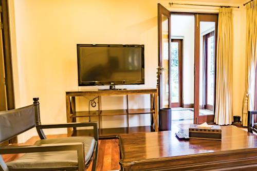 a living room with a flat screen tv and a table at Pawanthorn Samui - SHA Plus in Chaweng
