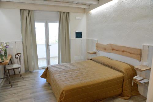 a bedroom with a bed and a large window at Masseria Santa Teresa in Monopoli