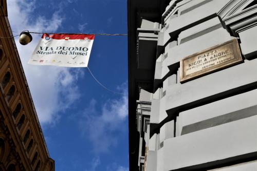 a sign on the side of a building with a banner at Napoli Mariana Luxury in Naples