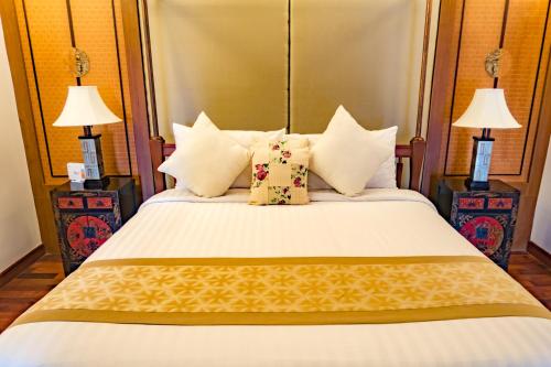 a bedroom with a large white bed with pillows at Pawanthorn Samui - SHA Plus in Chaweng
