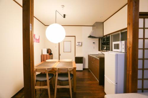 a kitchen with a table and chairs and a refrigerator at Private House HidaTakayama in Takayama