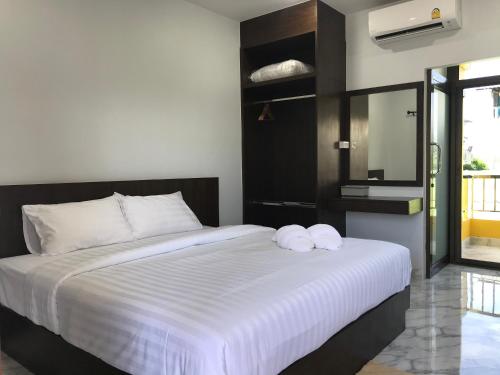 a bedroom with a large bed with two towels on it at G-HAN Residence in Nai Yang Beach