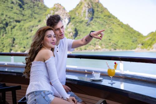 a man and a woman sitting at a table at Scarlet Pearl Cruises - Wonder On Lan Ha Bay in Ha Long