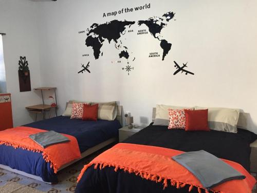 Sunrise Apartment في فاليتا: غرفة نوم بسريرين مع خريطة العالم