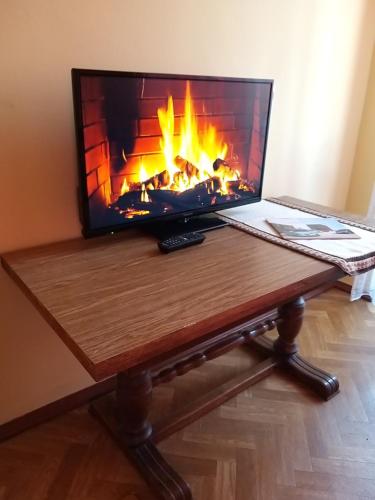 a laptop sitting on a table with a fireplace at ZА in Khmelʼnytsʼkyy