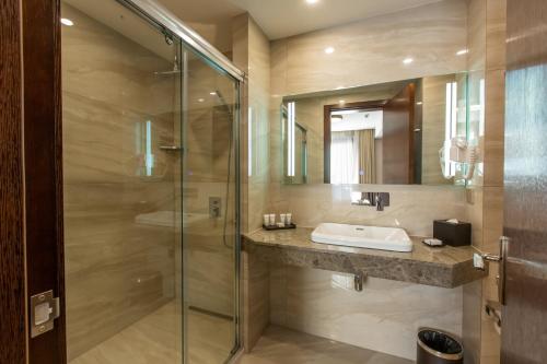 a bathroom with a sink and a glass shower at KMM Hotel in Tbilisi City