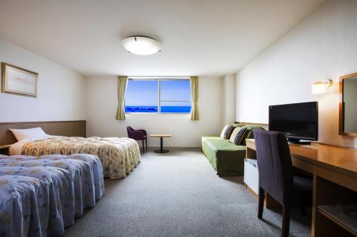 Habitación de hotel con 2 camas y escritorio en Island Inn Rishiri, en Rishirifuji