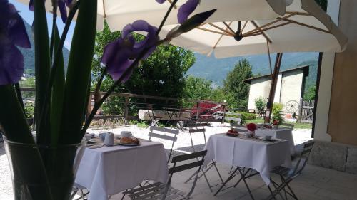 two tables with purple flowers in a vase at La Villa degli Orti in Borgo