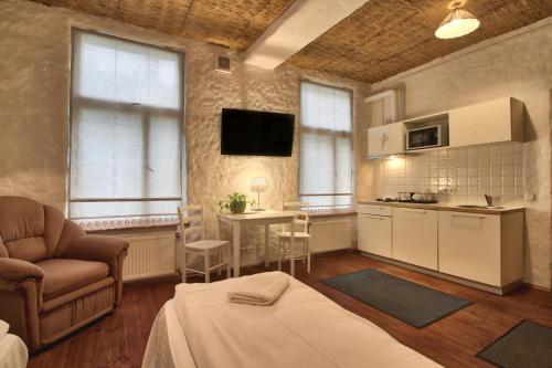 a living room with a kitchen and a table with chairs at Flatmanagement Kaupmehe Apartments in Tallinn