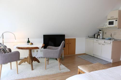 ein Wohnzimmer mit einem Tisch und einer Küche in der Unterkunft Landhaus Schmitt in Sommerach