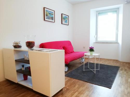 a living room with a red couch and a table at City center apartment in Umag