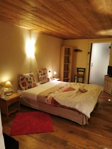 a bedroom with a large bed with a wooden ceiling at Maison Le Cler in Valtournenche