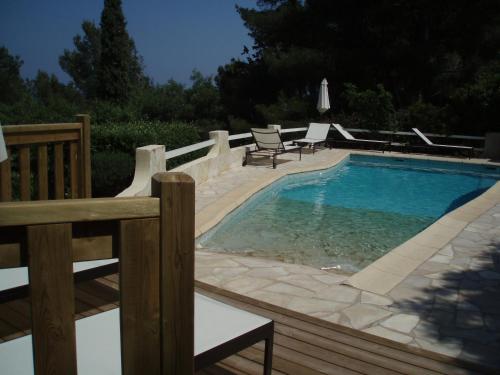 uma piscina com duas cadeiras e uma mesa ao lado em Villa Fabregas em La Seyne-sur-Mer