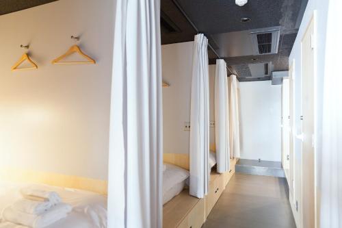 1 dormitorio con cortinas blancas y 1 cama. en Area Inn Fushimicho Fukuyama Castle Side 2-8, en Fukuyama