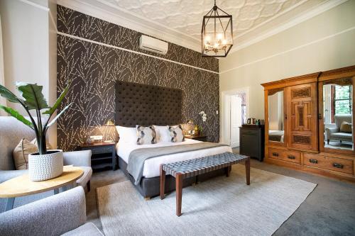 a bedroom with a large bed and a couch at Bonne Esperance Boutique Guest House in Stellenbosch