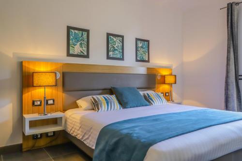 een slaapkamer met een groot bed en 2 lampen bij Hotel Restaurant San Lucianu in Moriani Plage