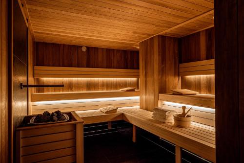sauna z drewnianymi ścianami oraz drewnianym stołem i ławkami w obiekcie Platinum Apartments w Szklarskiej Porębie