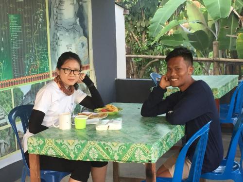 a man and a woman sitting at a table at Bukit Senaru Homestay in Senaru