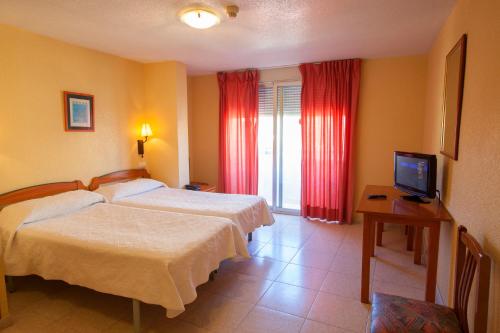 
a hotel room with a bed and a television at Hotel Carmen Almuñécar by Bossh Hotels in Almuñécar
